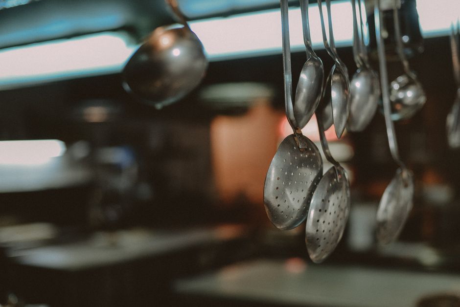 Detalj obješenih metalnih žlica i kutlača u kuhinji
