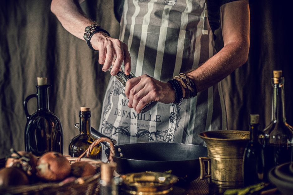 Kuhar priprema tradicionalno jelo uz začine i ulje