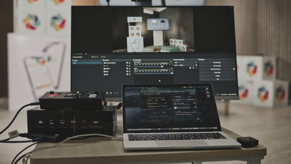 Multimedijski setup s laptopom i velikim monitorom u tehnološkom radnom prostoru
