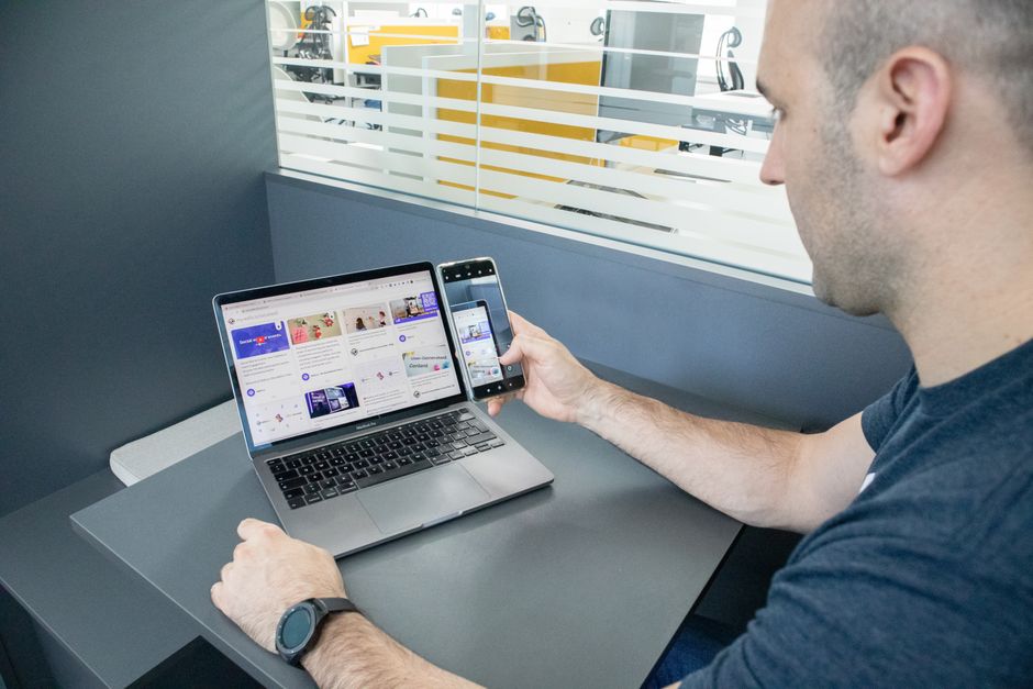 Čovjek koristi laptop i pametni telefon u modernom uredskom prostoru